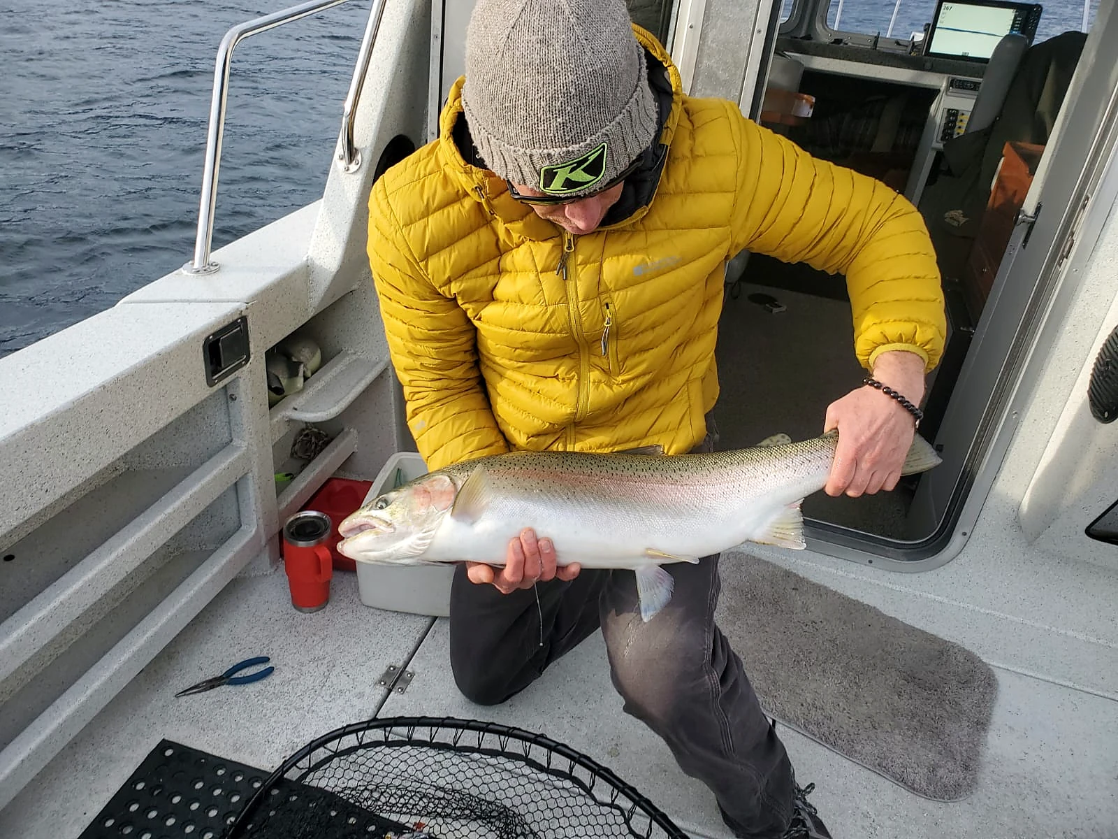 Guest with a rainbow trout on the Kingfisher deck